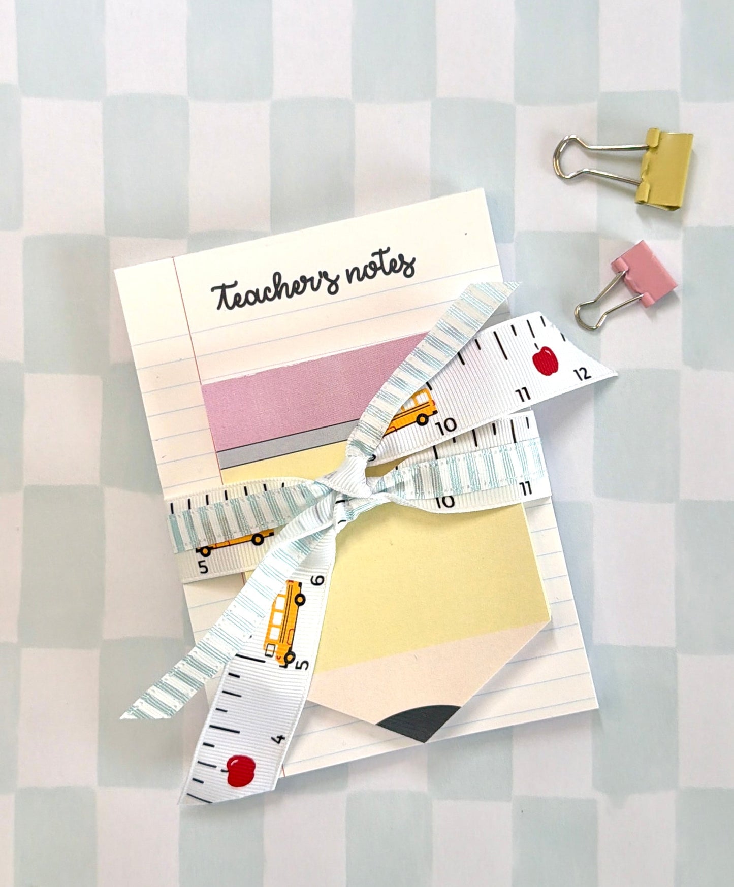Notebook, ruler, and clips on a checkered background