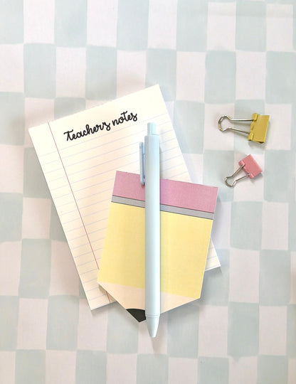 Notebook, pen, and clips on a checkered background