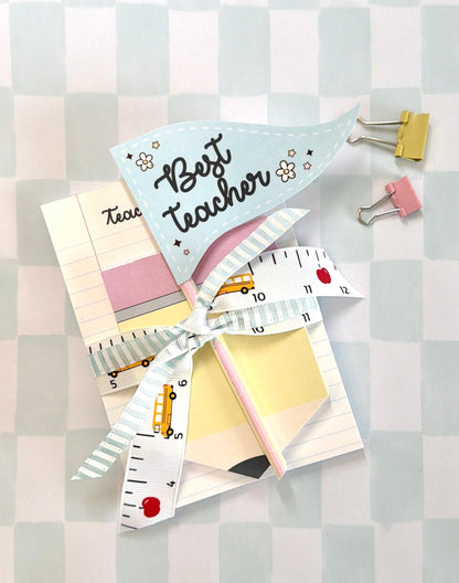Stationery items including a pen, paper clips, and a small notepad on a checkered background