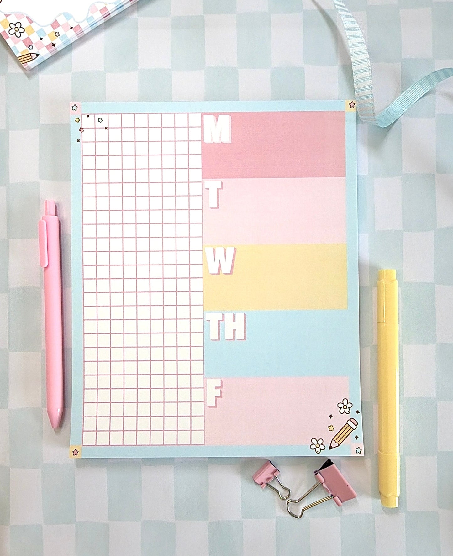 Pastel-colored planner with grid and notes on a checkered background