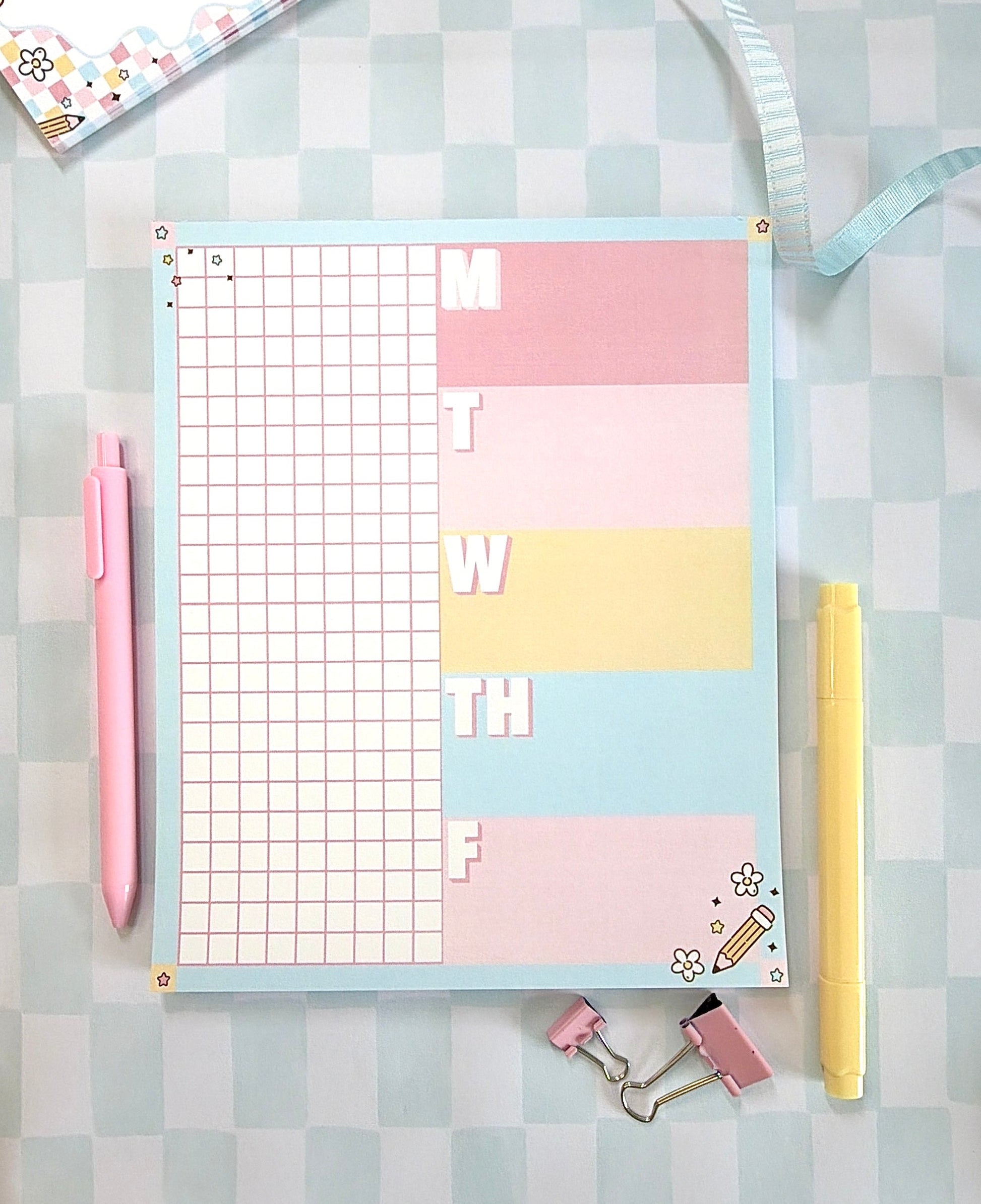 Pastel-colored planner with grid and notes on a checkered background
