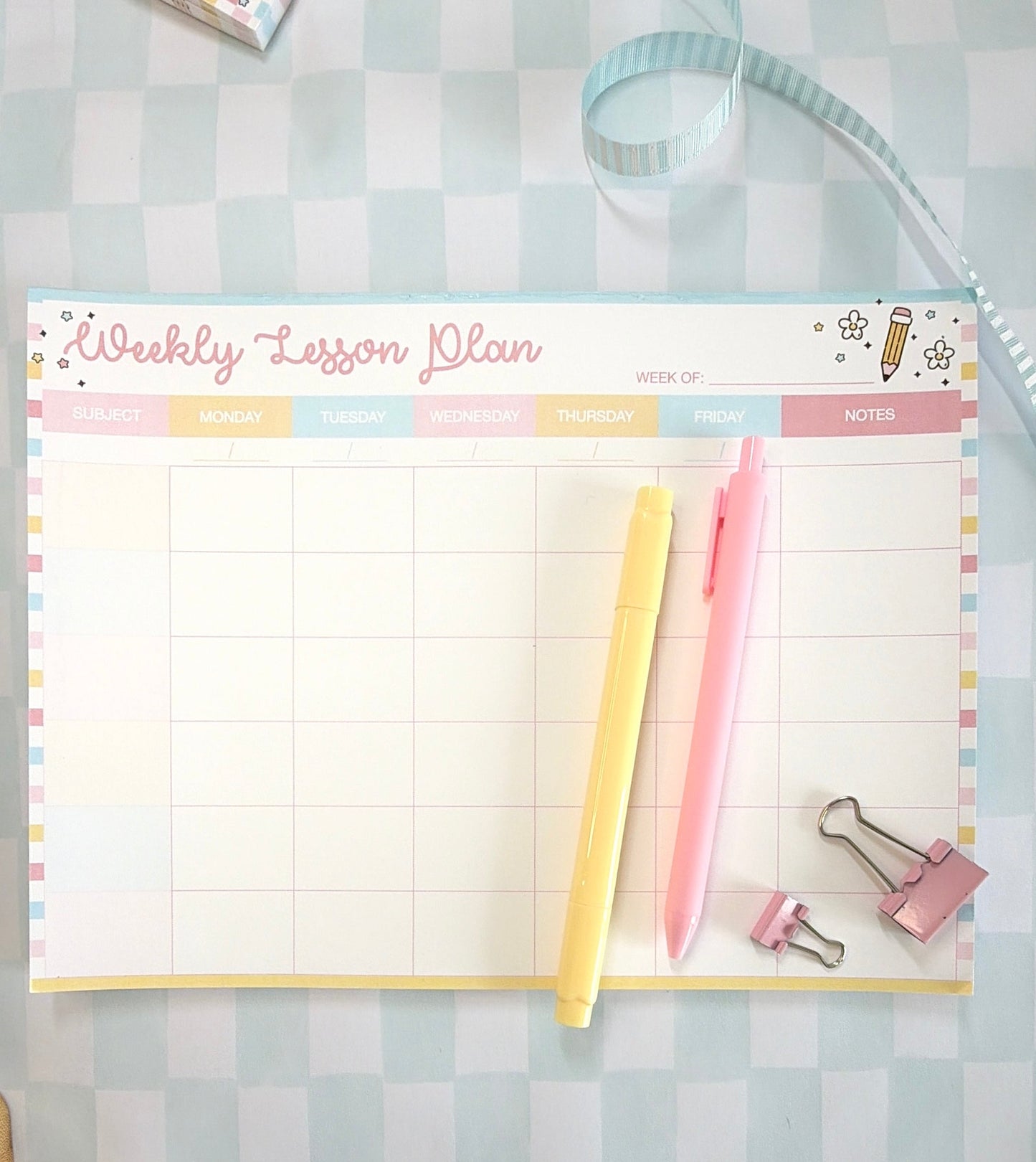 Weekly lesson plan pad with stationery items on a checkered background